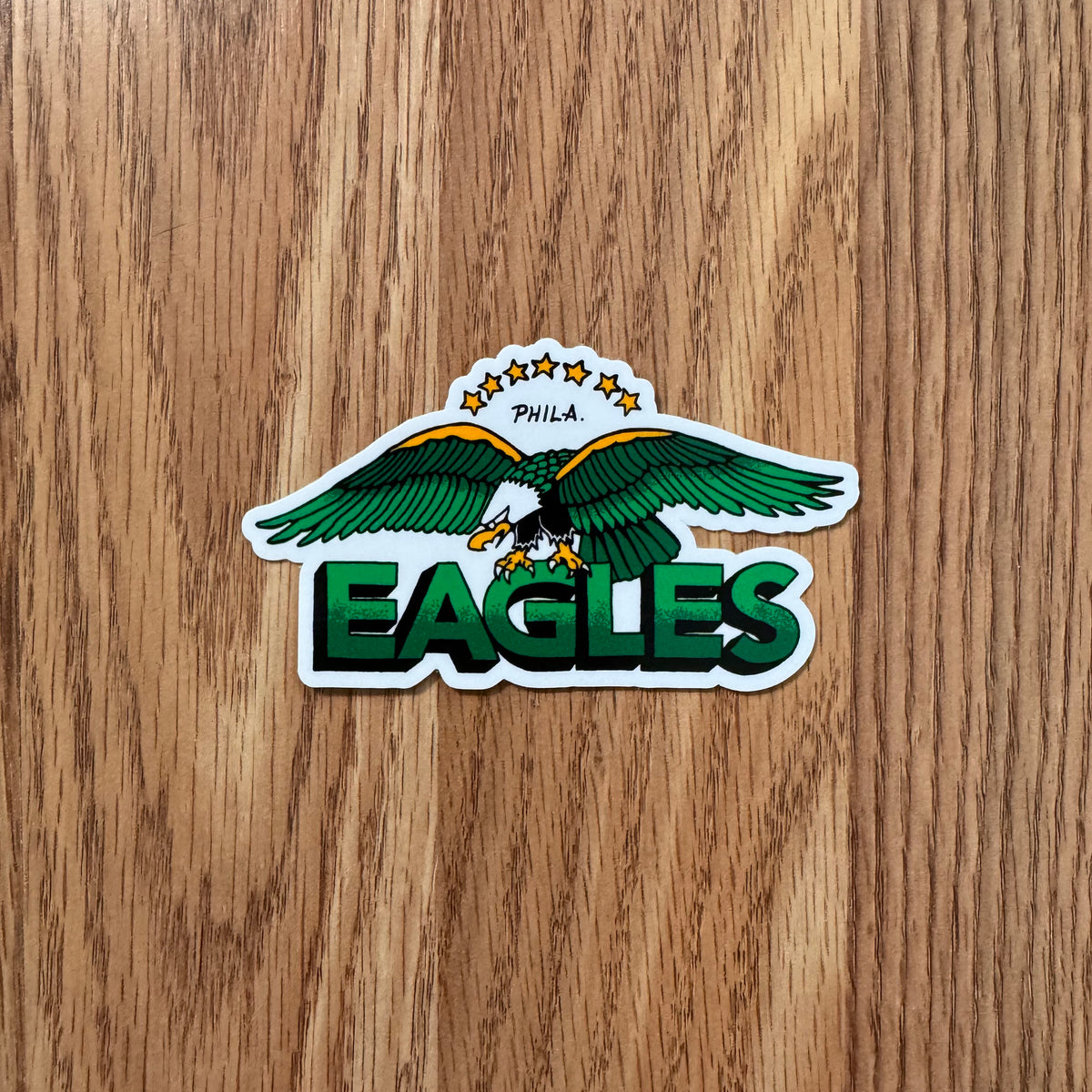 Sticker of an eagle with 'EAGLES' text on a wooden surface