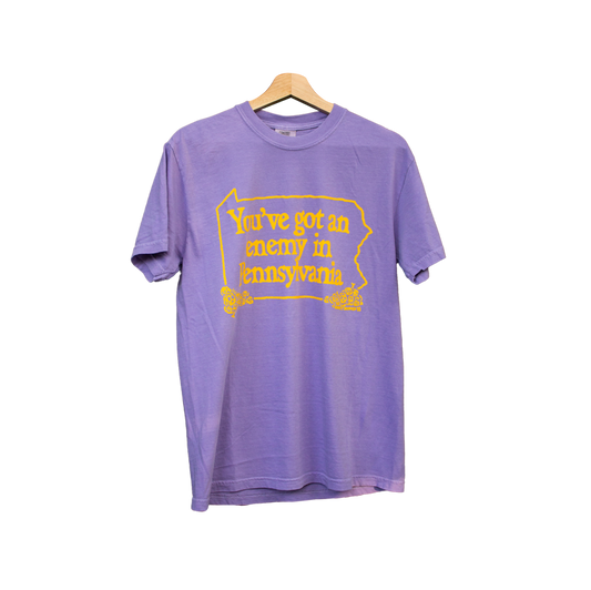 Purple t-shirt with yellow text on a white background