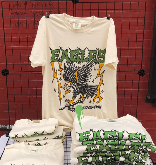 White t-shirt with eagle graphic design on a grid background