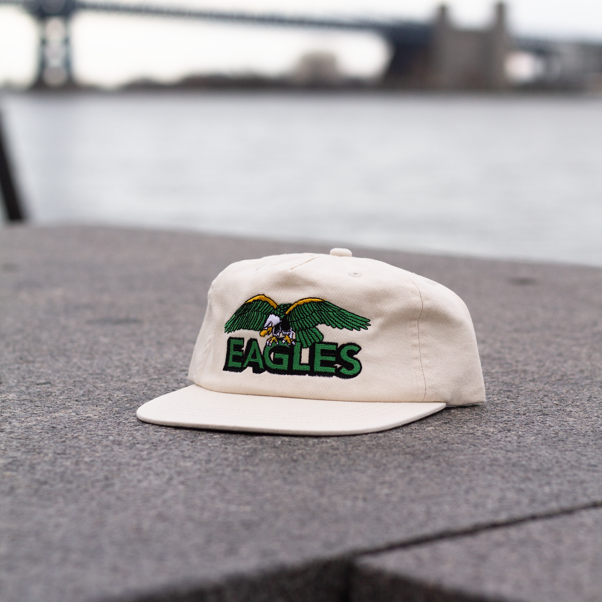 White cap with 'EAGLES' logo on a textured surface