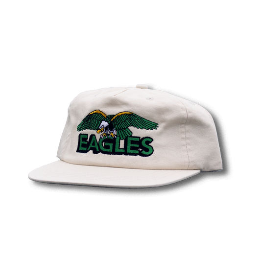 White cap with green and yellow eagle design and 'EAGLES' text on a white background