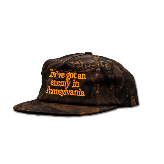 Camouflage cap with text 'You've got an enemy in Pennsylvania' on a white background