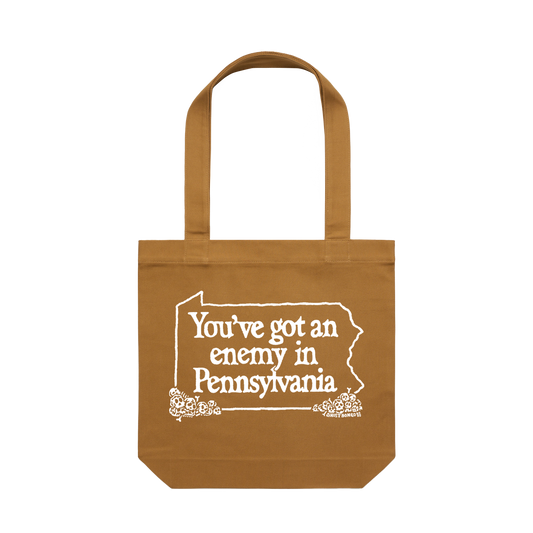 Brown tote bag with white text "you've got an enemy in Pennsylvania" and design