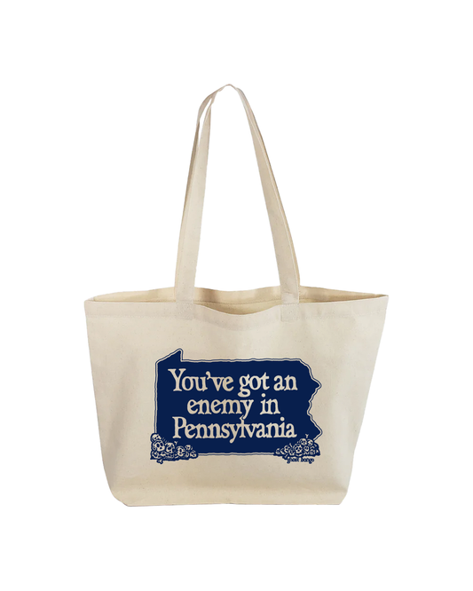 Beige tote bag with blue text 'You've got an enemy in Pennsylvania' on a white background