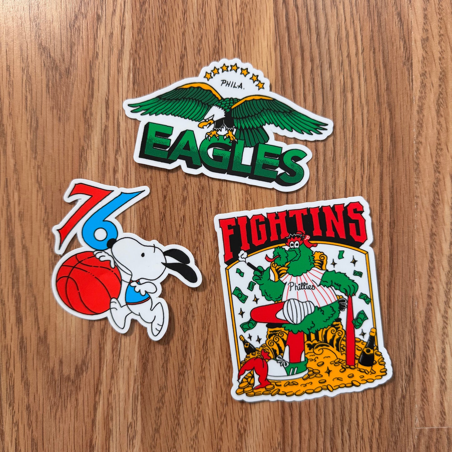 Three sports-themed stickers on a wooden surface